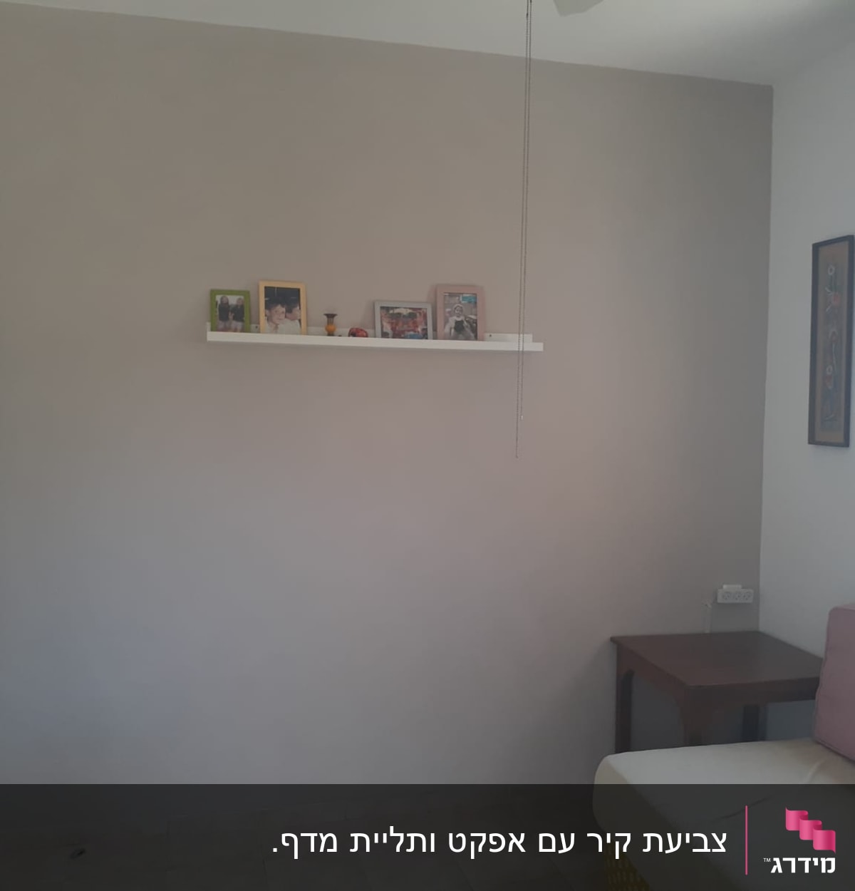 קיר צבוע בגוון אפור בהיר עם מדף לבן